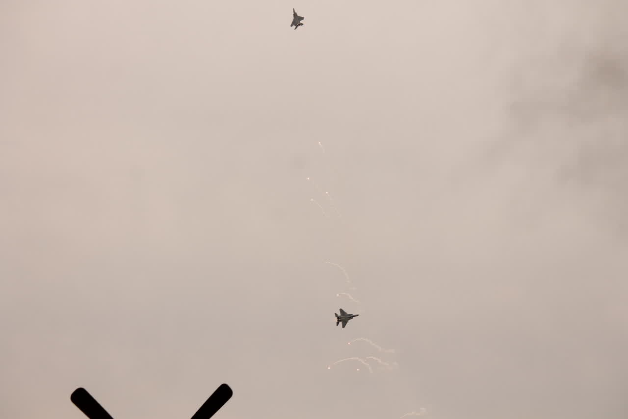 מטוס F-15C משחרר נורים מיד לאחר ההמראה, שובלי עשן לבנים מאחוריו